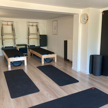 Salle de cours de Pilates sur appareils avec reformers et tapis dans un studio à Heiligenstein en Alsace